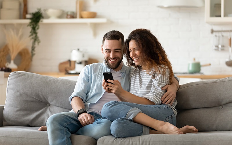 couple on couch looking at phone